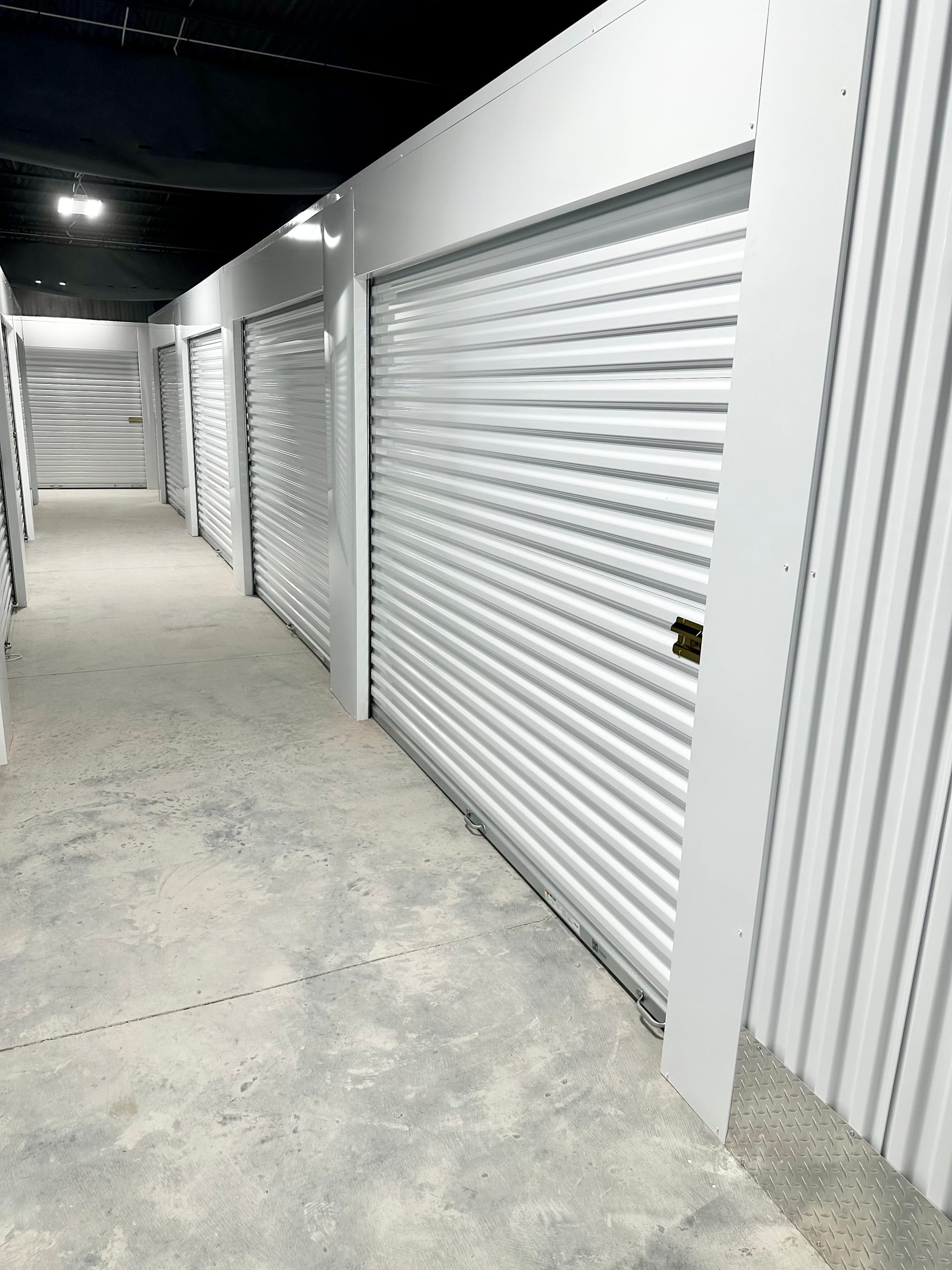 Indoor hallway of white roll-up unit doors at Storage Park Dayton